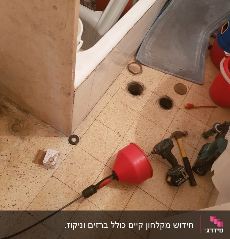 כלי עבודה של אינסטלטור על רצפת חדר אמבטיה